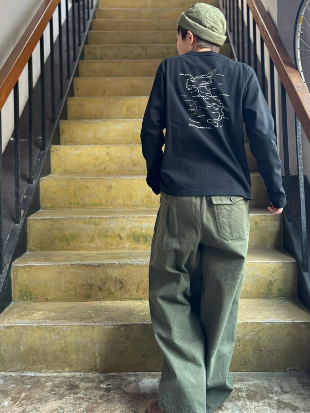 グリーン系のその他パンツ、ブラック系のTシャツ/カットソー、グリーン系の帽子を着用したレディースの冬コーディネートの2枚目の写真