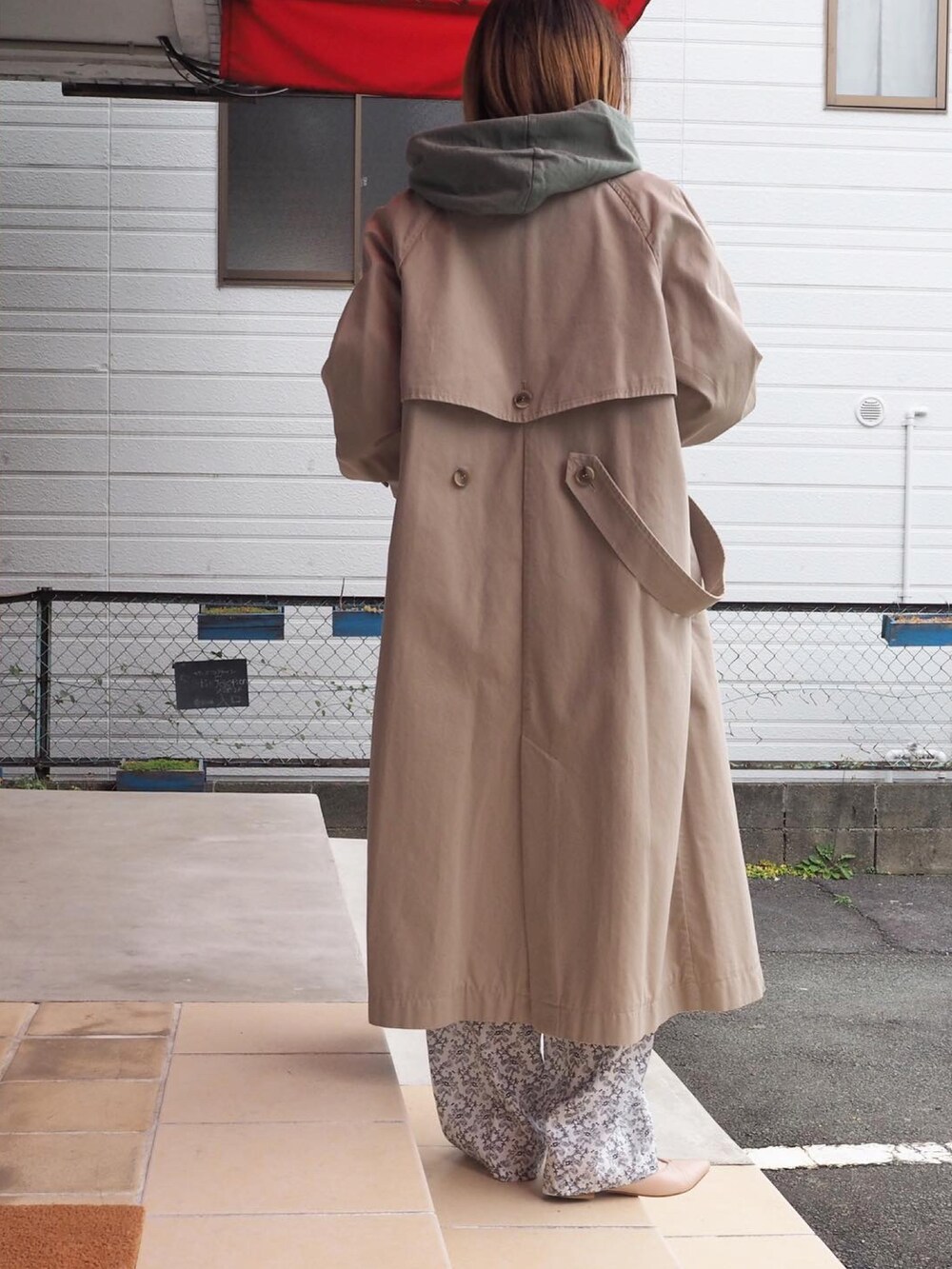 ホワイト系のパーカー、ベージュ系のトレンチコート、ホワイト系のその他パンツを着用したレディースの冬コーディネートの3枚目の写真