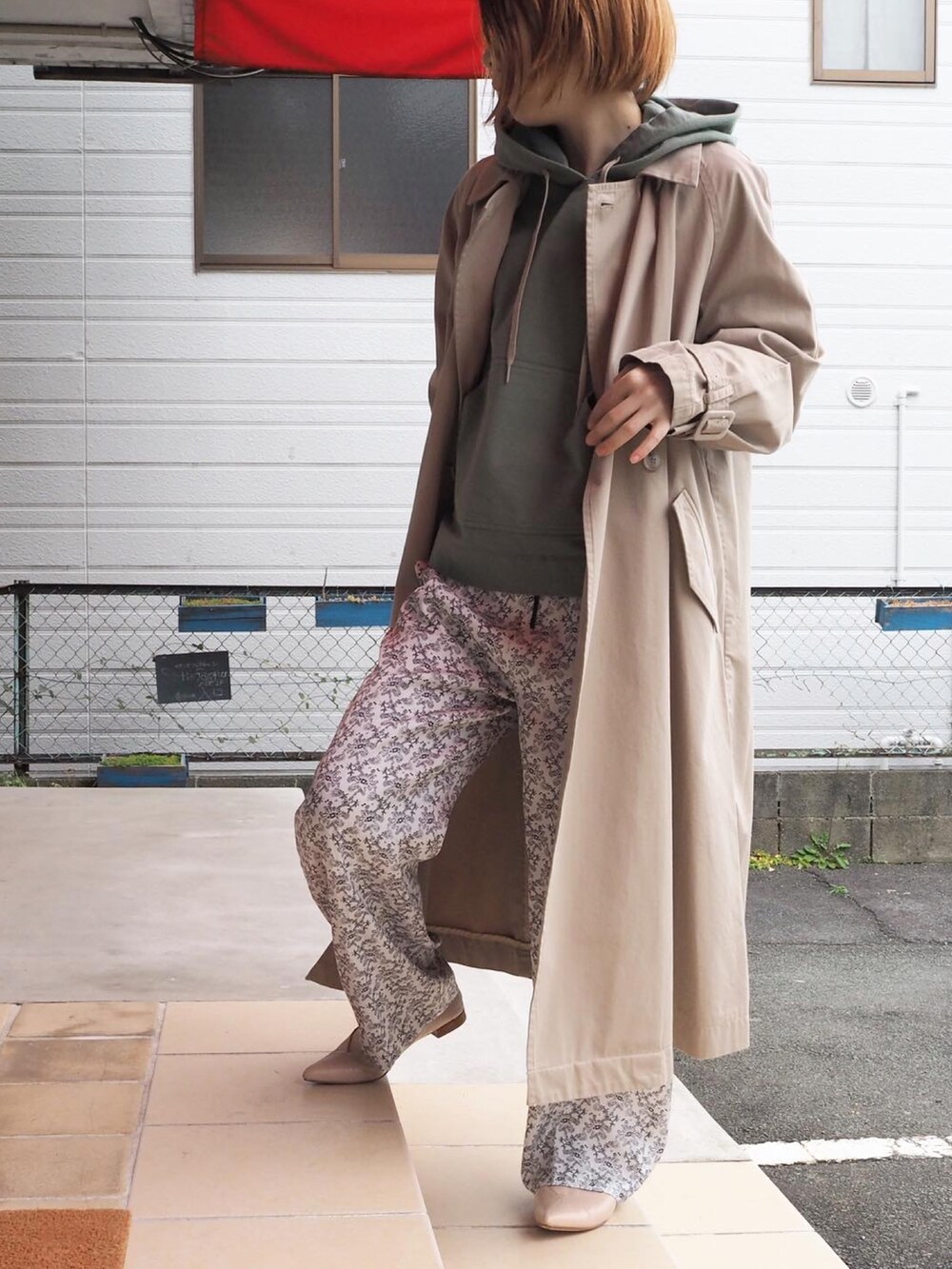 ホワイト系のパーカー、ベージュ系のトレンチコート、ホワイト系のその他パンツを着用したレディースの冬コーディネートの2枚目の写真