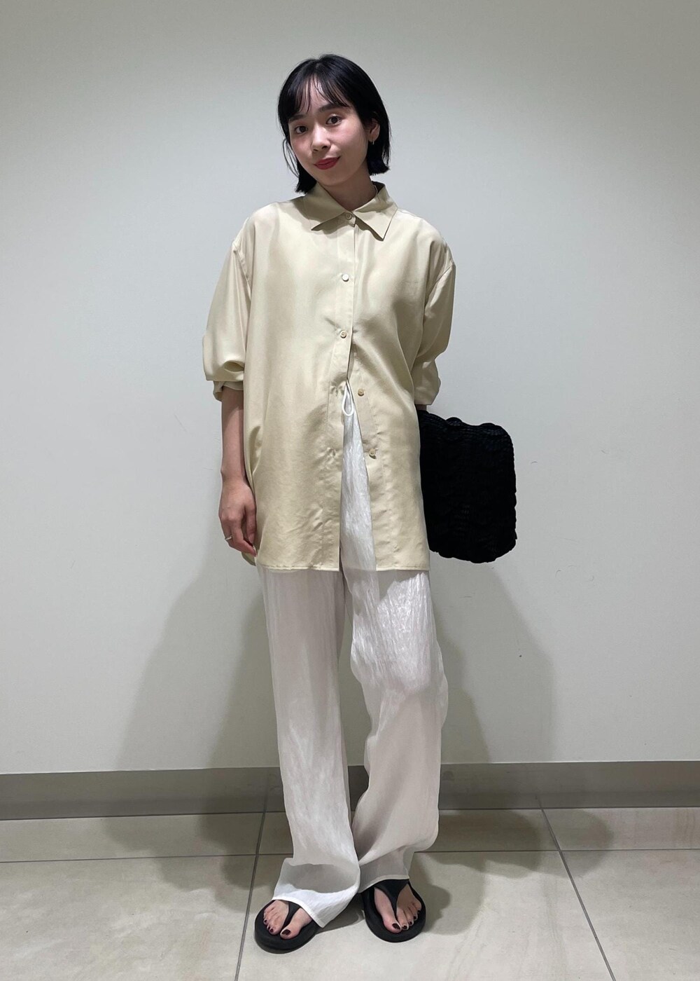 ホワイト系のその他パンツ、ブラック系のハンドバッグ、ベージュ系のシャツ/ブラウスを着用したレディースの夏コーディネートの2枚目の写真