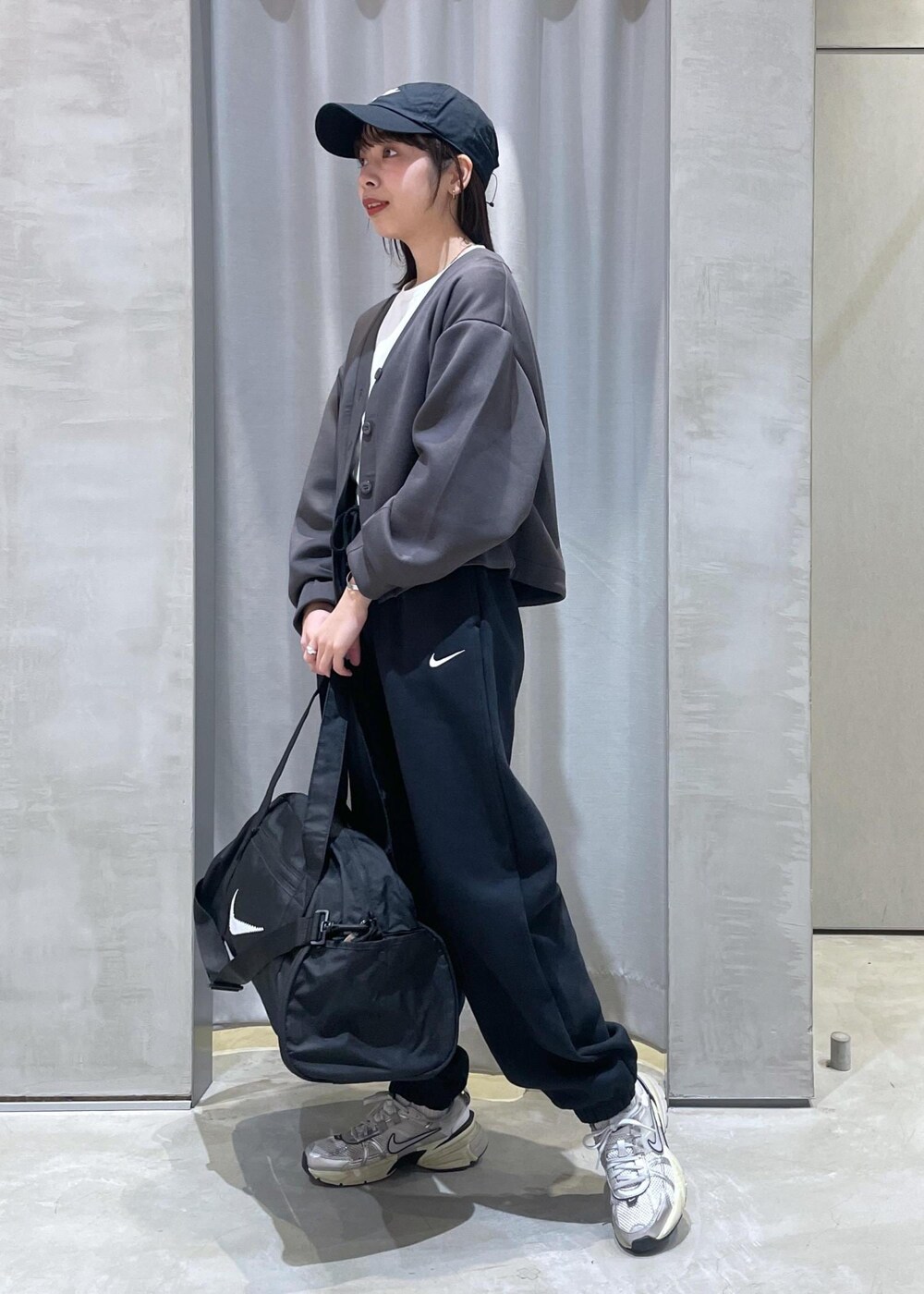 ホワイト系のスニーカー、ブラック系のボストンバッグ、グレー系のカーディガン/ボレロを着用したレディースの冬コーディネートの3枚目の写真