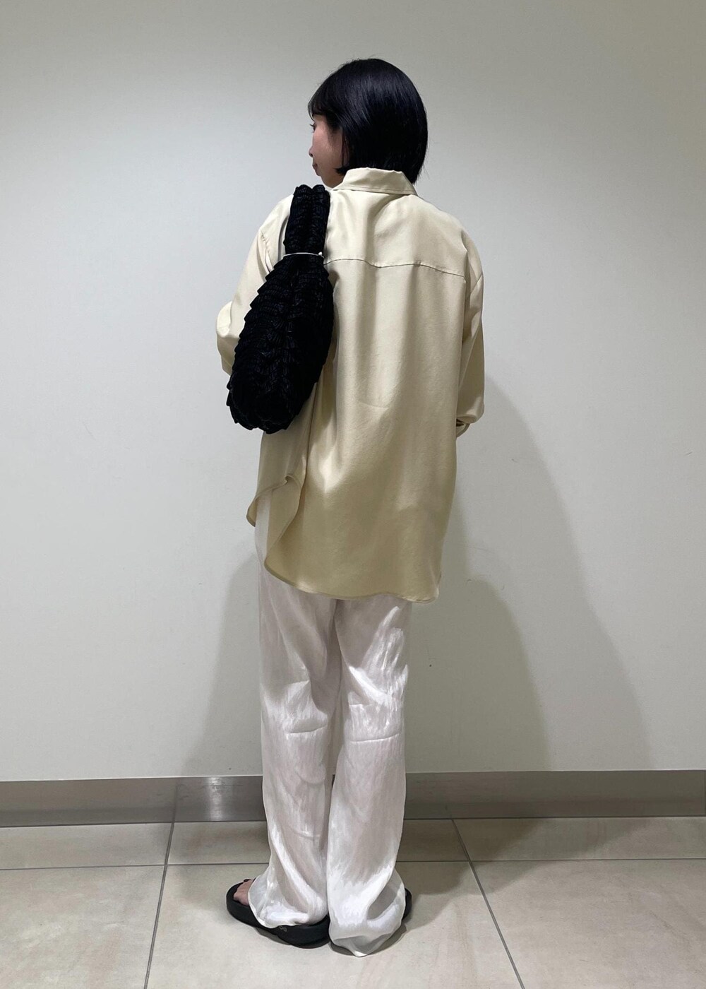 ホワイト系のその他パンツ、ブラック系のハンドバッグ、ベージュ系のシャツ/ブラウスを着用したレディースの夏コーディネートの3枚目の写真