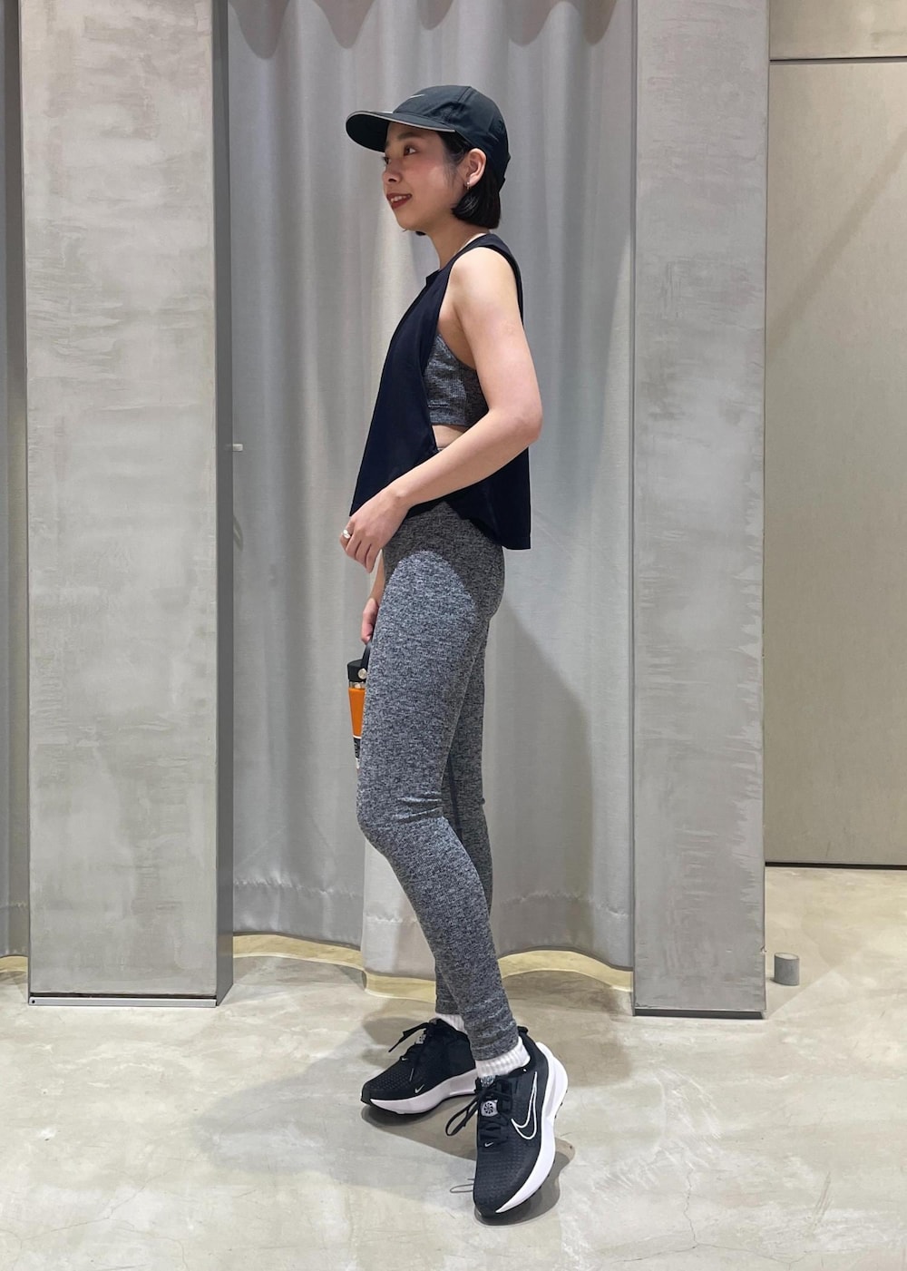 ブラック系のタンクトップ、ブラック系のスニーカー、ブラック系のキャップを着用したレディースの冬コーディネートの2枚目の写真