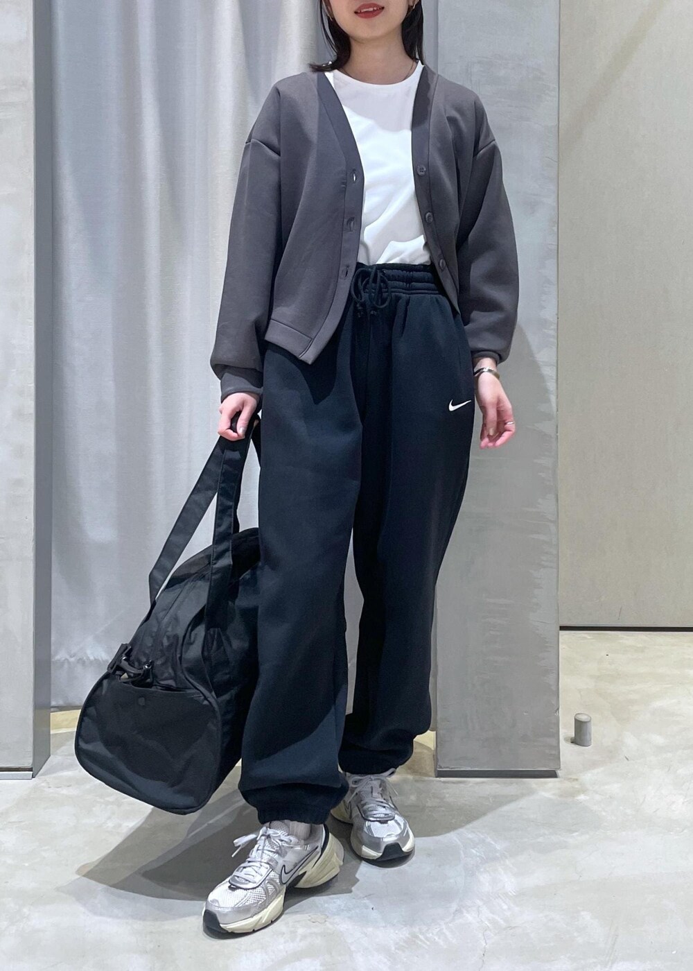 ホワイト系のスニーカー、ブラック系のボストンバッグ、グレー系のカーディガン/ボレロを着用したレディースの冬コーディネートの5枚目の写真