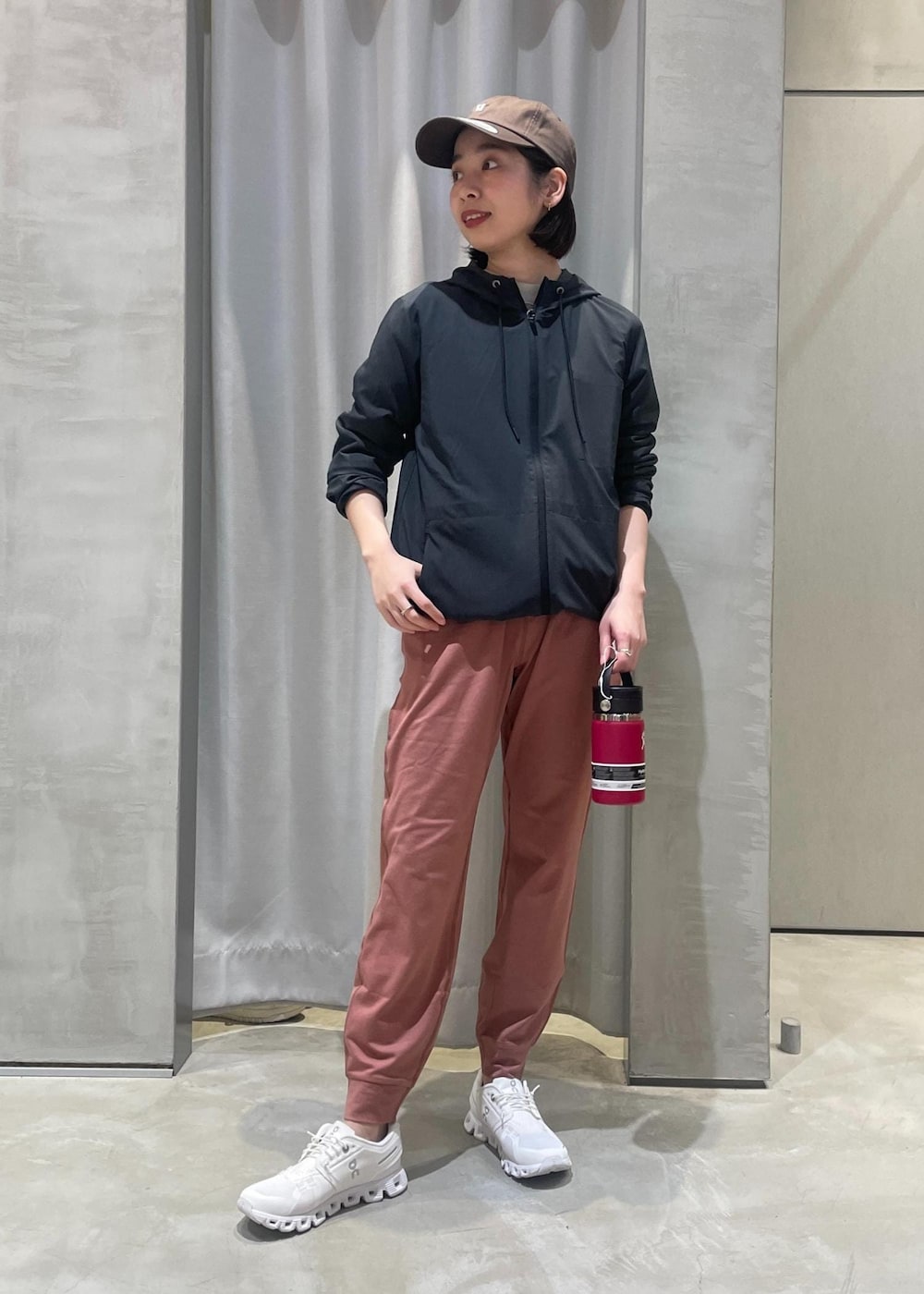 ホワイト系のスニーカー、ブラック系のマウンテンパーカー、レッド系のグラス/マグカップ/タンブラーを着用したレディースの春コーディネートの2枚目の写真