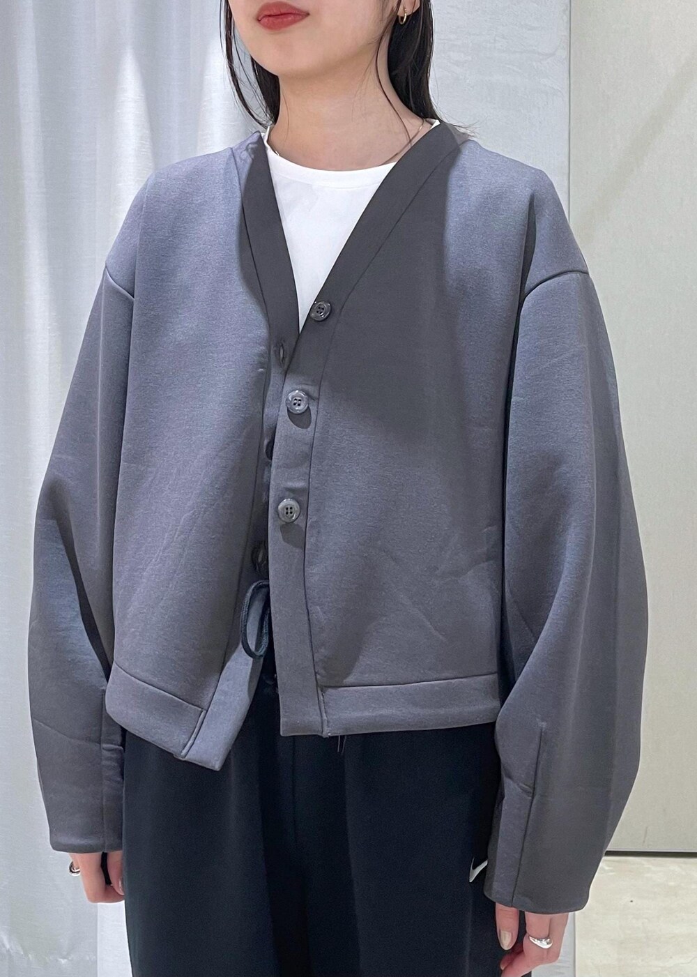 ホワイト系のスニーカー、ブラック系のボストンバッグ、グレー系のカーディガン/ボレロを着用したレディースの冬コーディネートの6枚目の写真