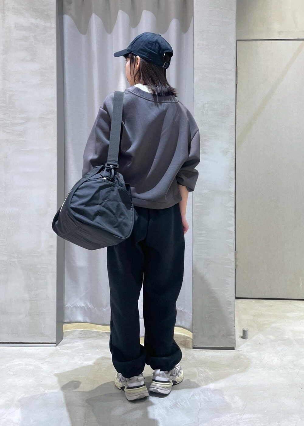 ホワイト系のスニーカー、ブラック系のボストンバッグ、グレー系のカーディガン/ボレロを着用したレディースの冬コーディネートの4枚目の写真