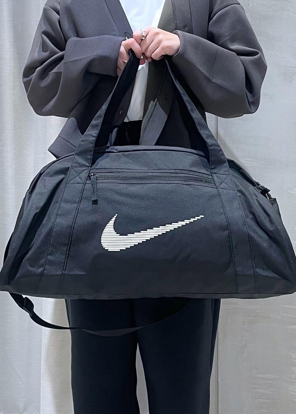 ホワイト系のスニーカー、ブラック系のボストンバッグ、グレー系のカーディガン/ボレロを着用したレディースの冬コーディネートの8枚目の写真