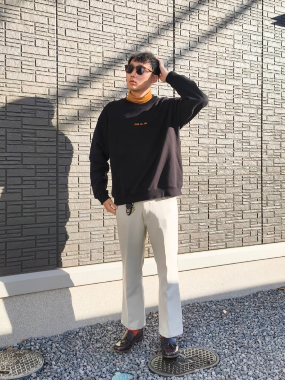 ブラウン系のローファー、ホワイト系のその他パンツ、ブラック系のスウェットを着用したメンズの秋コーディネートの2枚目の写真