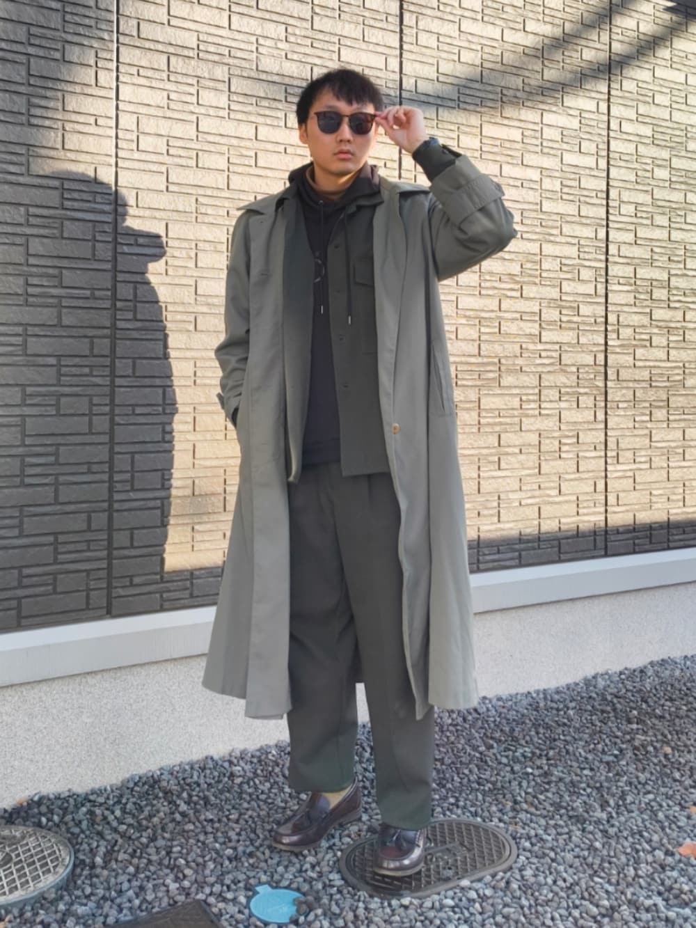 ブラウン系のローファー、グリーン系のスラックス、グリーン系のセットアップを着用したメンズの秋コーディネートの2枚目の写真