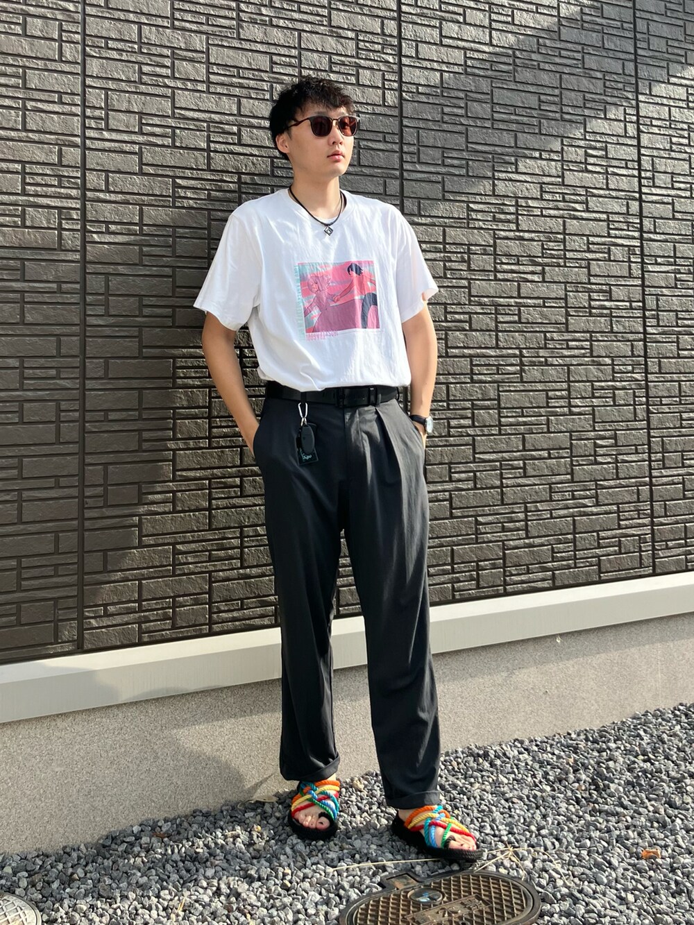 ブラック系のサンダル、グレー系のスラックス、ホワイト系のTシャツ/カットソーを着用したメンズの秋コーディネートの2枚目の写真