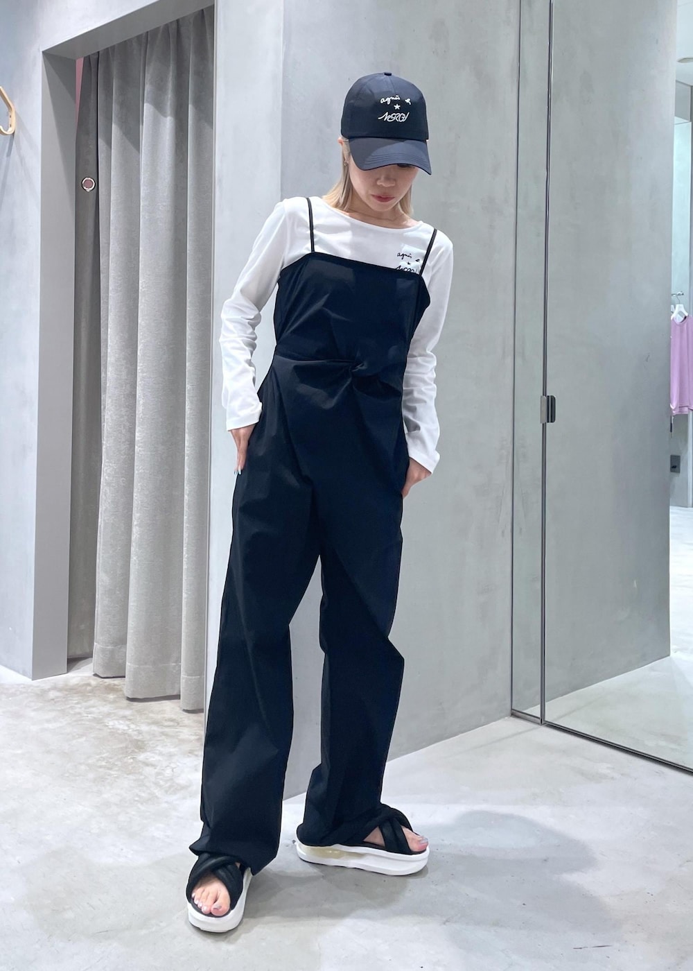 ブラック系のサンダル、ホワイト系のTシャツ/カットソー、ブラック系のサロペット/オーバーオールを着用したレディースの夏コーディネートの4枚目の写真