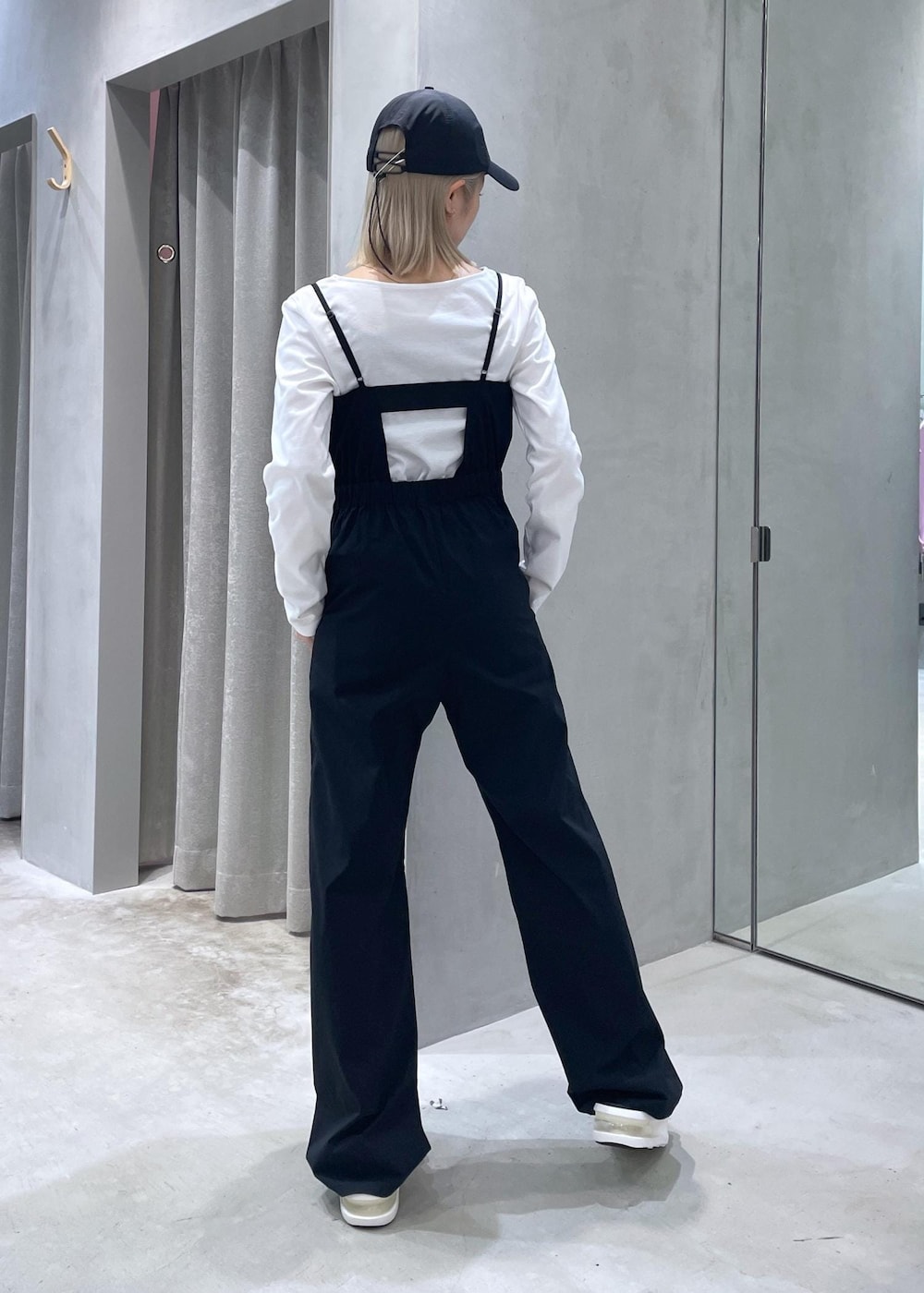 ブラック系のサンダル、ホワイト系のTシャツ/カットソー、ブラック系のサロペット/オーバーオールを着用したレディースの夏コーディネートの3枚目の写真