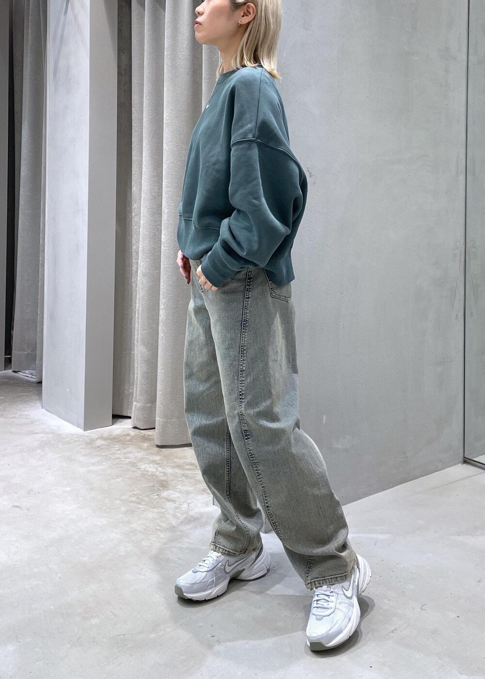 ベージュ系のデニムパンツ、グレー系のスニーカー、グリーン系のスウェットを着用したレディースの秋コーディネートの2枚目の写真