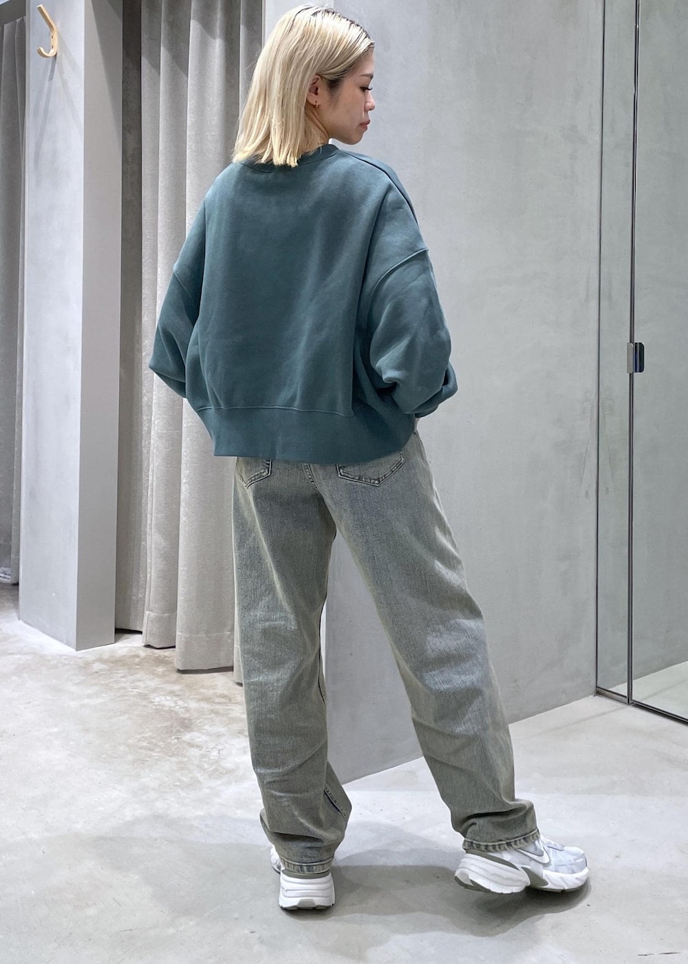 ベージュ系のデニムパンツ、グレー系のスニーカー、グリーン系のスウェットを着用したレディースの秋コーディネートの3枚目の写真