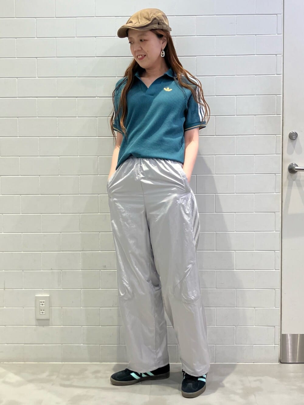 グリーン系のポロシャツ、グレー系のその他パンツ、ブラック系のスニーカーを着用したレディースの夏コーディネートの3枚目の写真