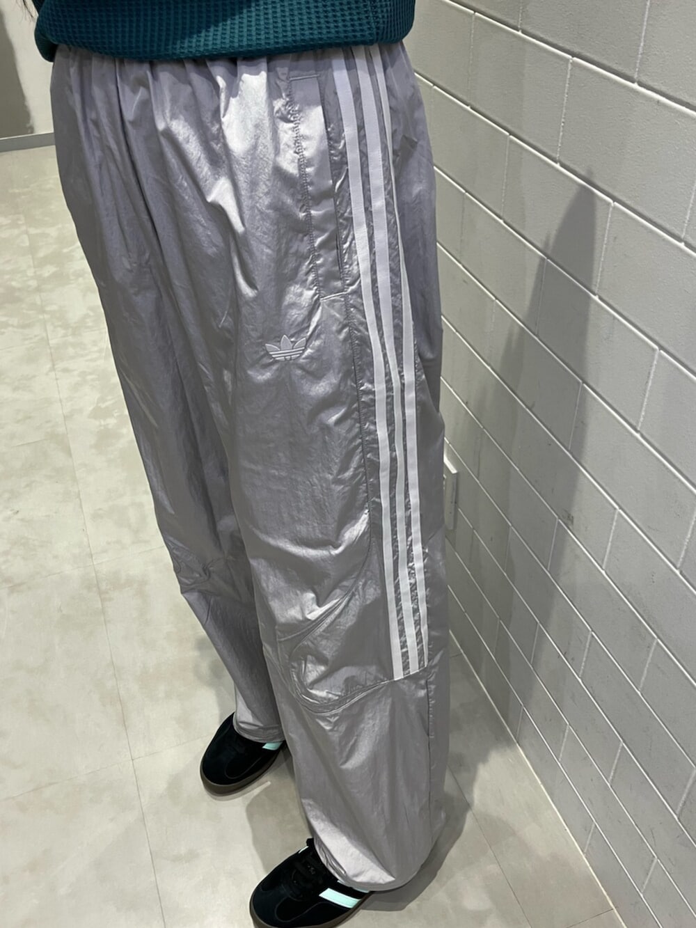 グリーン系のポロシャツ、グレー系のその他パンツ、ブラック系のスニーカーを着用したレディースの夏コーディネートの5枚目の写真