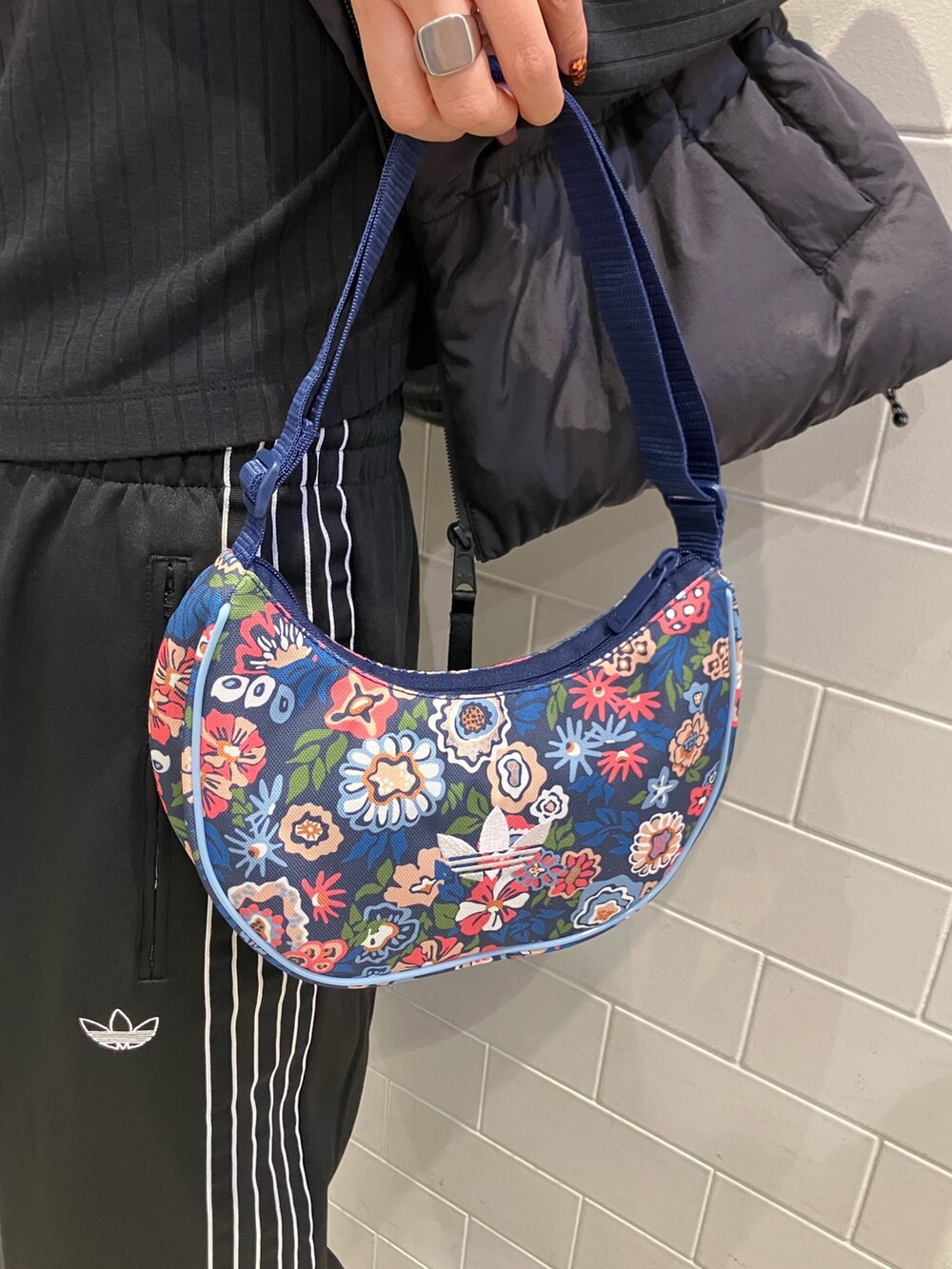 ブラック系のジャケット/アウター、ブラック系のTシャツ/カットソー、ブルー系のショルダーバッグを着用したレディースの冬コーディネートの3枚目の写真