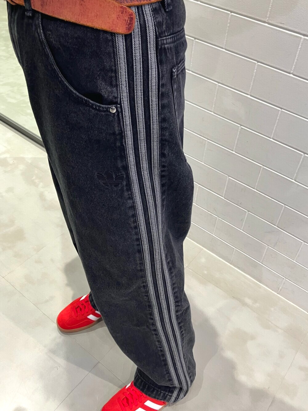 ホワイト系のトップス、ブラック系のデニムパンツ、ベージュ系のショルダーバッグを着用したレディースの夏コーディネートの5枚目の写真