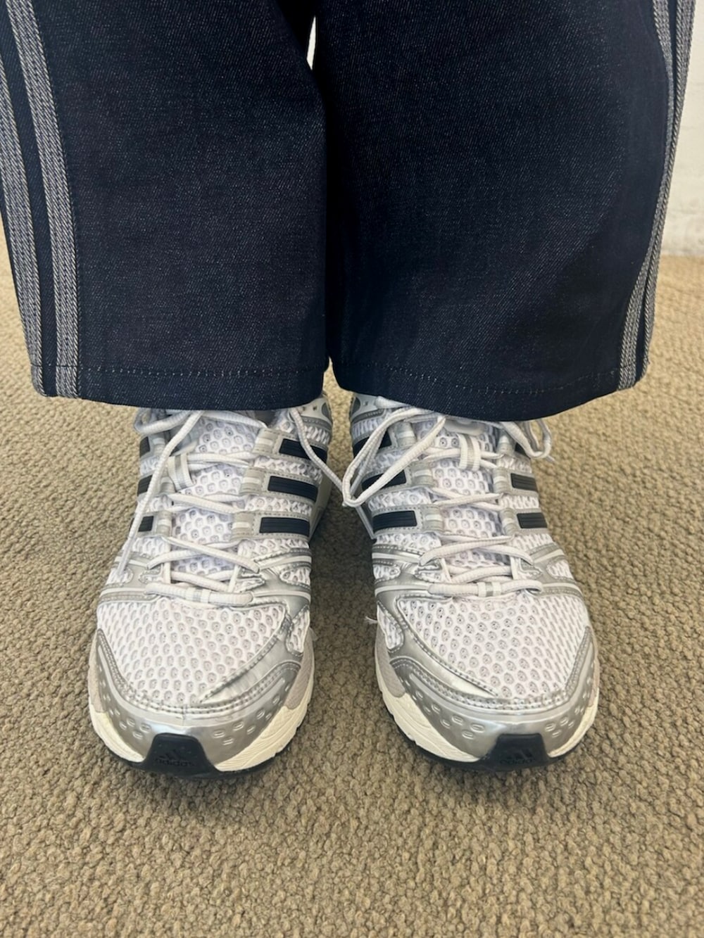 ホワイト系のTシャツ/カットソー、ブラック系のスカート、シルバー系のスニーカーを着用したレディースの春コーディネートの4枚目の写真