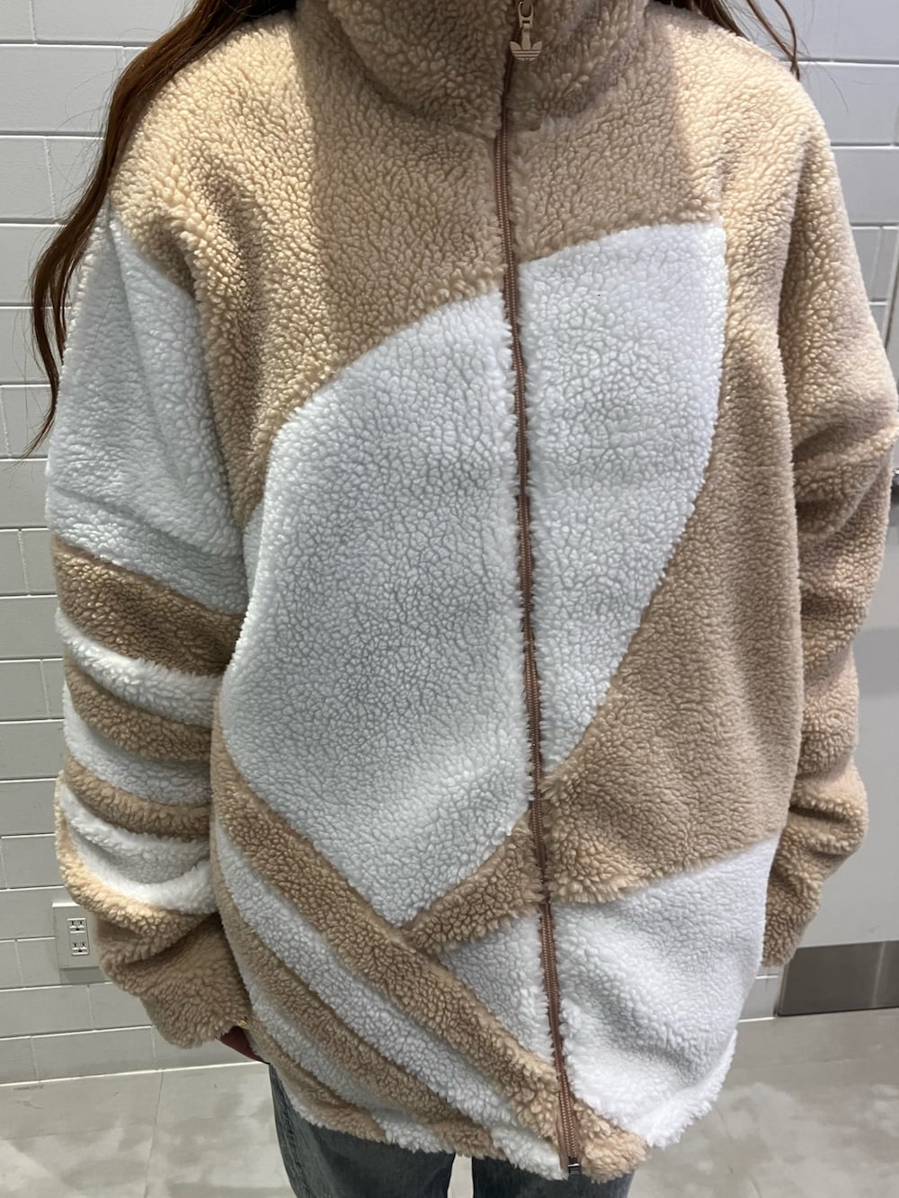 ベージュ系のブルゾン、ベージュ系のスニーカーを着用したレディースの冬コーディネートの3枚目の写真