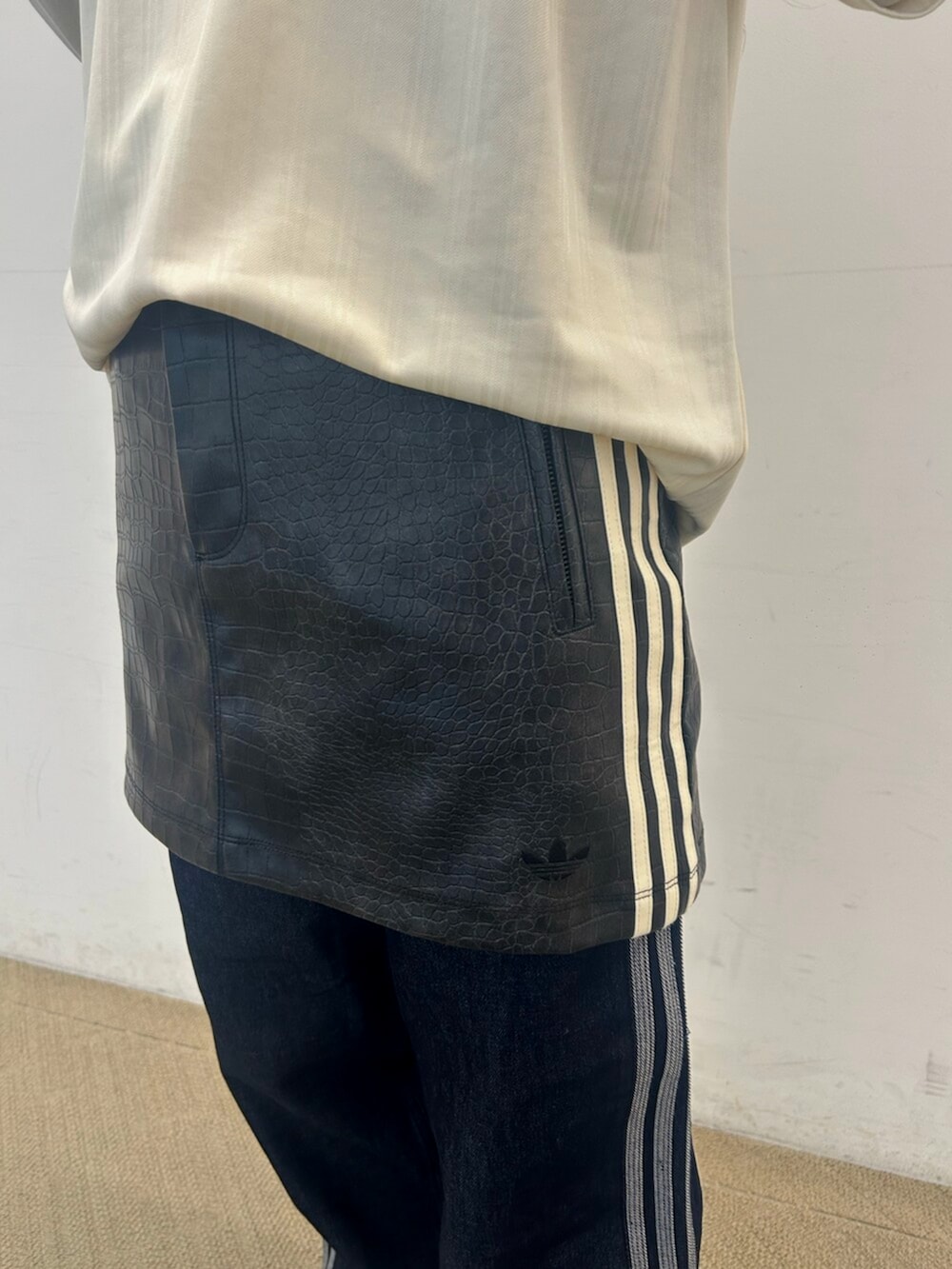 ホワイト系のTシャツ/カットソー、ブラック系のスカート、シルバー系のスニーカーを着用したレディースの春コーディネートの3枚目の写真