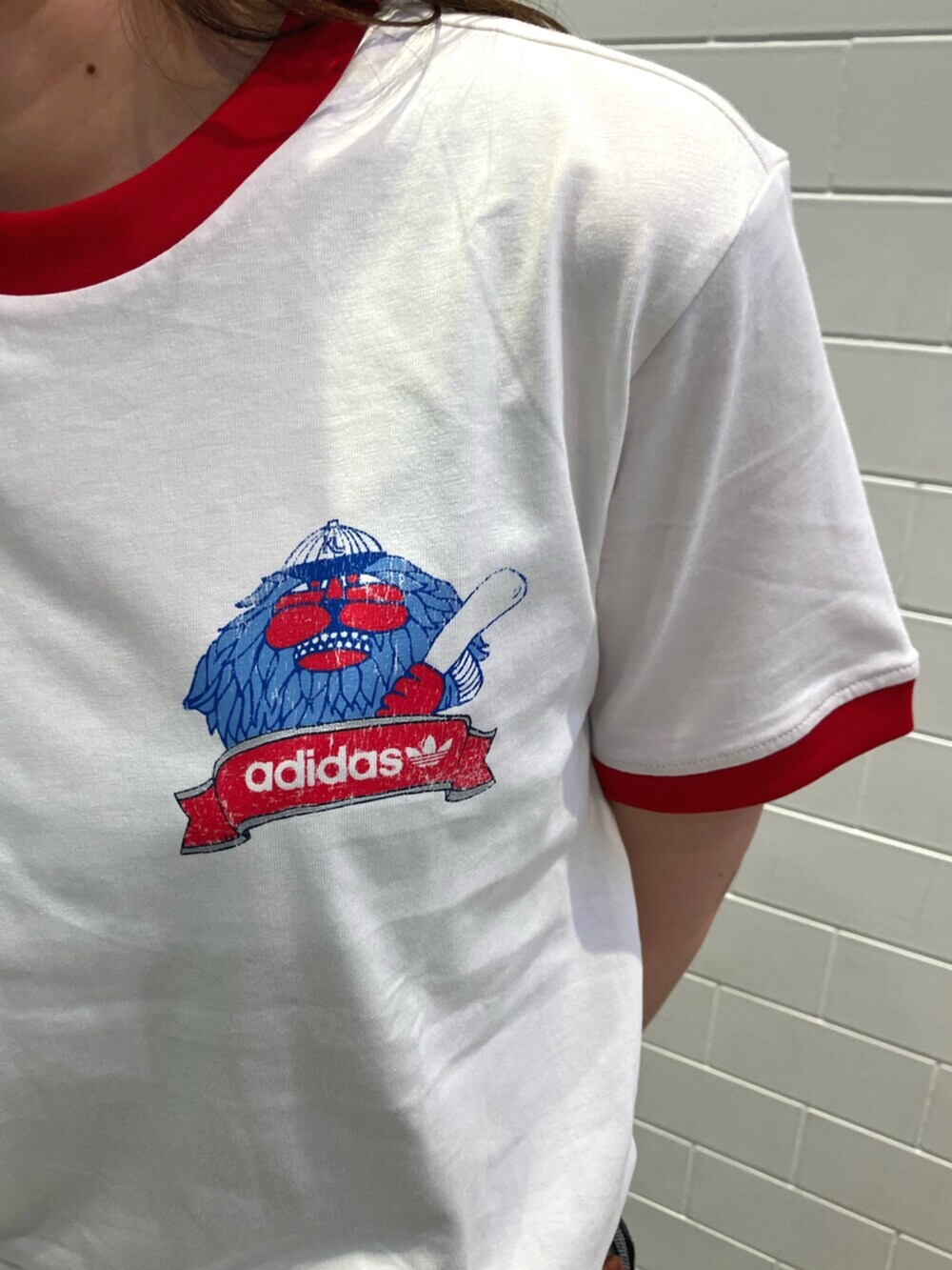 ホワイト系のトップス、ブラック系のデニムパンツ、ベージュ系のショルダーバッグを着用したレディースの夏コーディネートの3枚目の写真