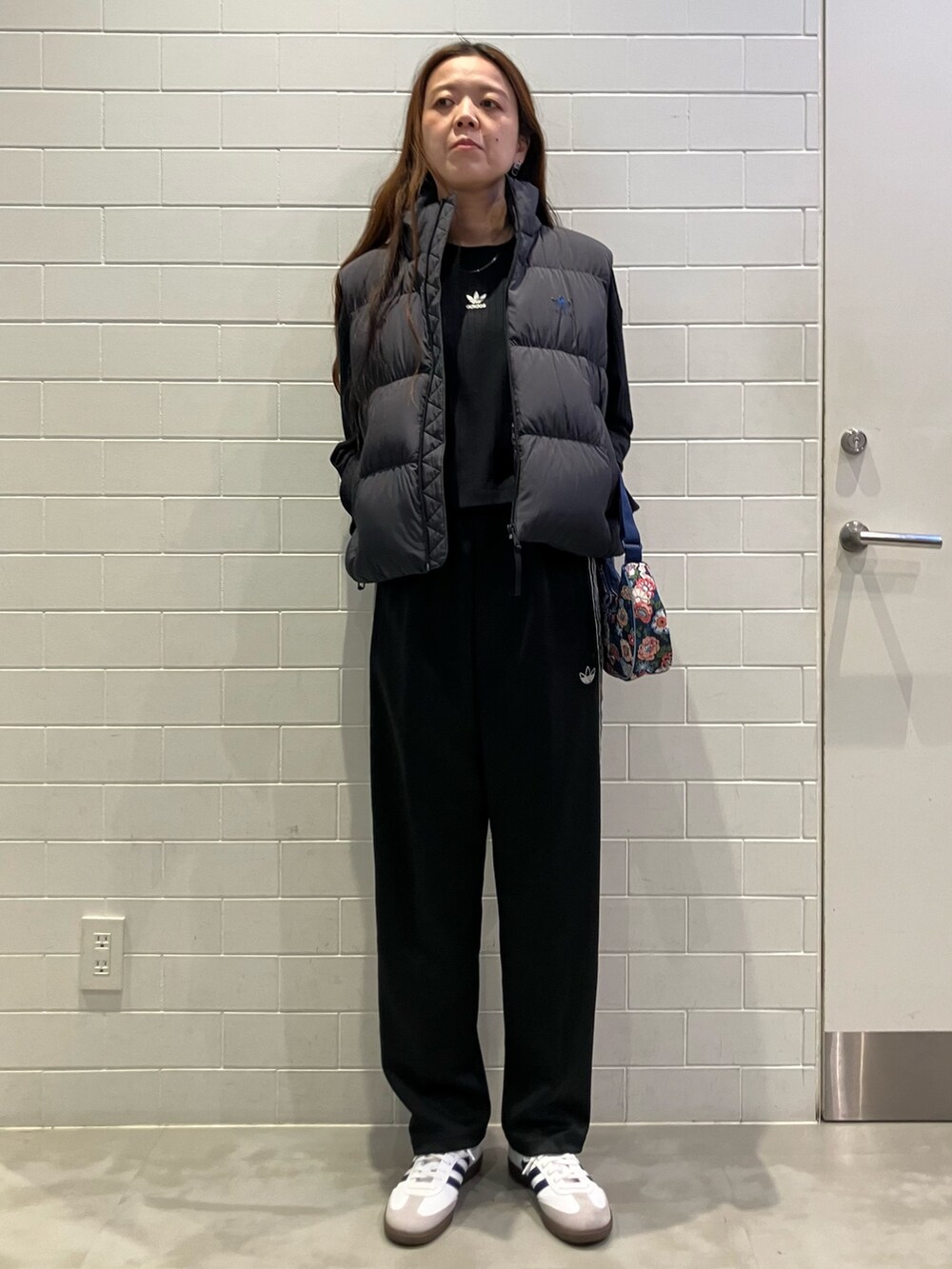 ブラック系のジャケット/アウター、ブラック系のTシャツ/カットソー、ブルー系のショルダーバッグを着用したレディースの冬コーディネートの2枚目の写真