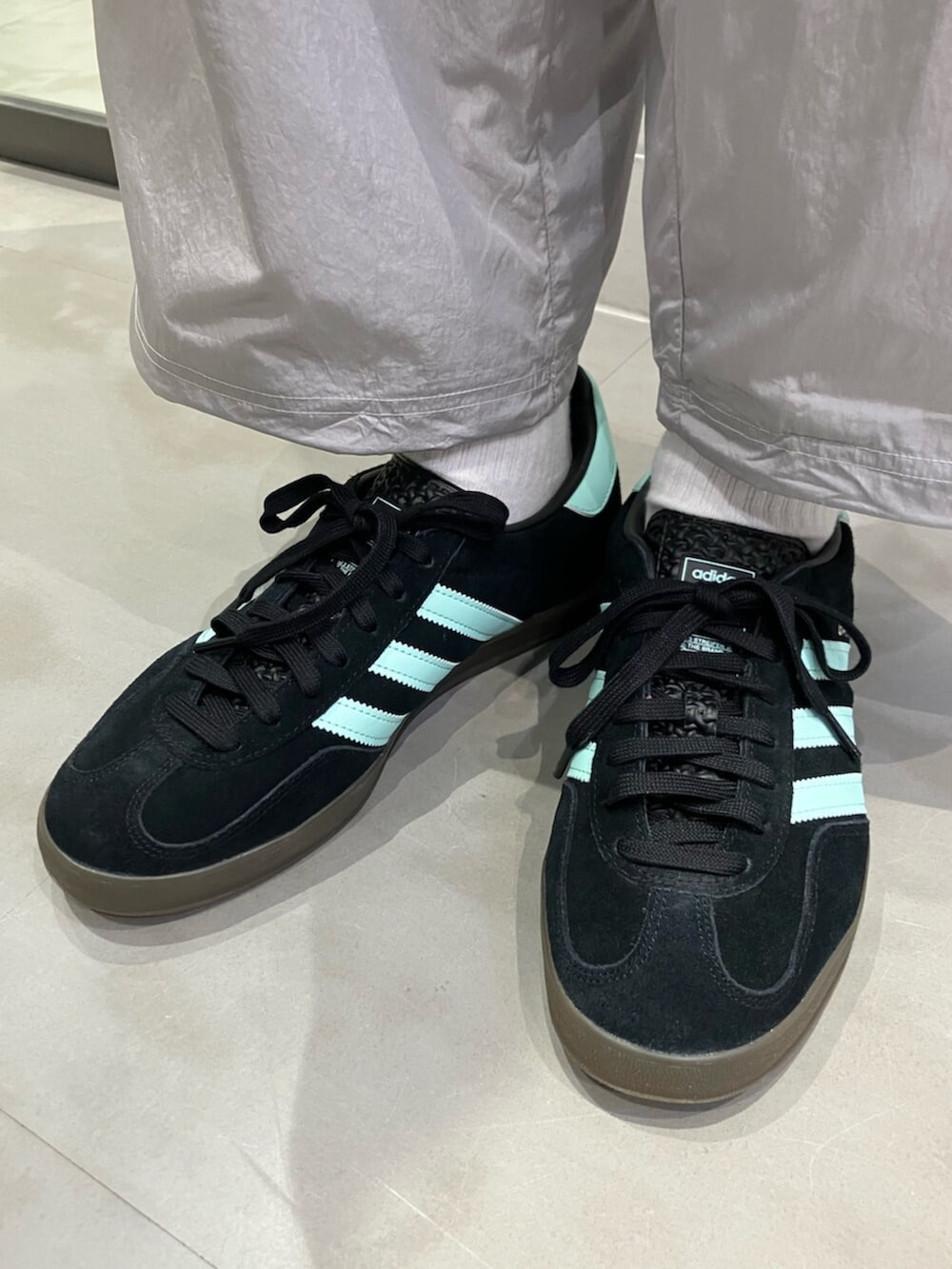 グリーン系のポロシャツ、グレー系のその他パンツ、ブラック系のスニーカーを着用したレディースの夏コーディネートの6枚目の写真