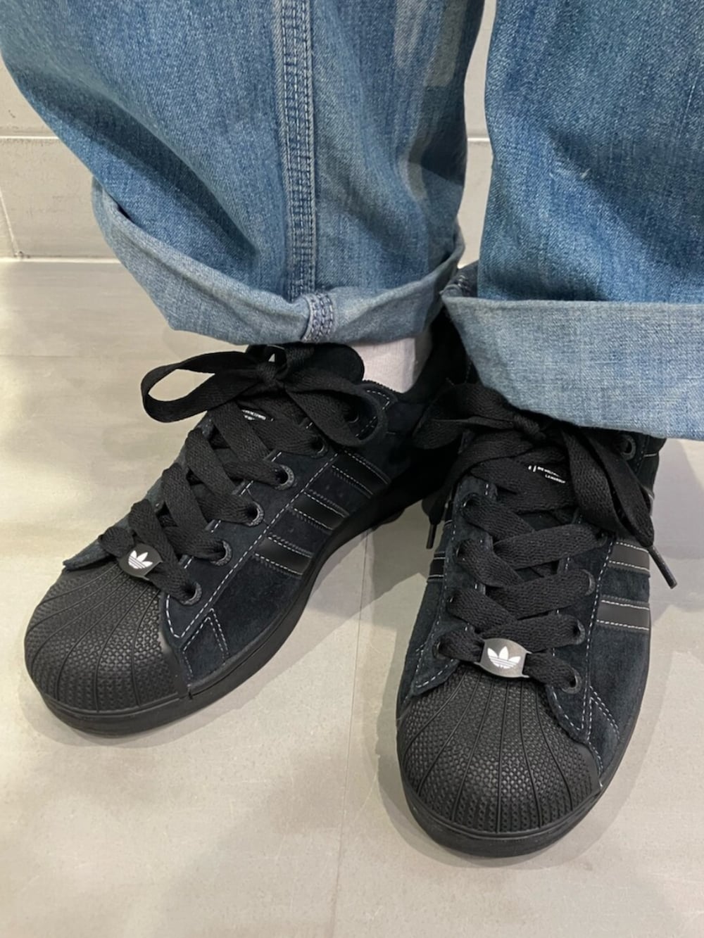 ホワイト系のジャージ、ブラック系のショルダーバッグ、ブラック系のスニーカーを着用したレディースの春コーディネートの4枚目の写真