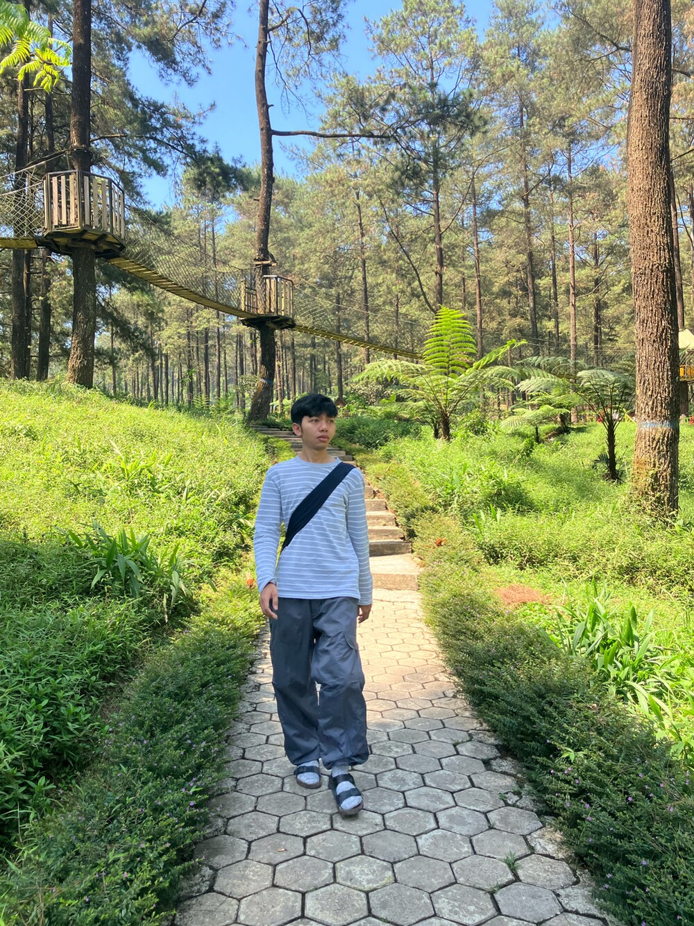 グレー系のTシャツ/カットソー、グレー系のパンツ、ブルー系のバッグを着用したメンズの秋コーディネートの2枚目の写真