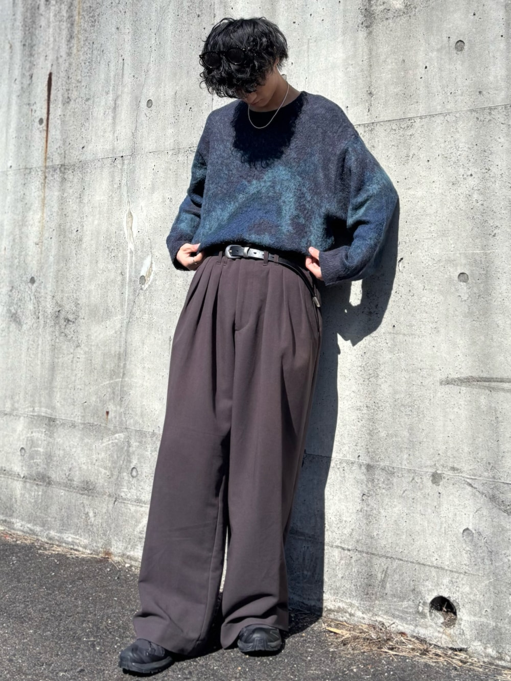 ブルー系のニット/セーター、ブラウン系のスラックス、ブラック系のスニーカーを着用したメンズの春コーディネートの5枚目の写真