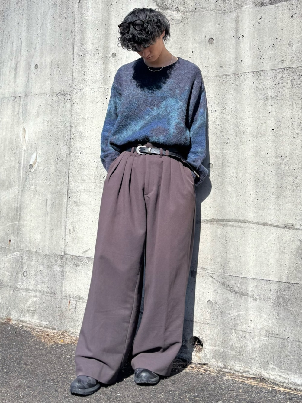 ブルー系のニット/セーター、ブラウン系のスラックス、ブラック系のスニーカーを着用したメンズの春コーディネートの3枚目の写真