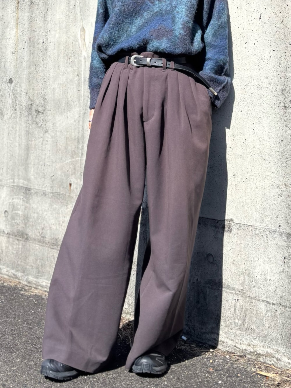 ブルー系のニット/セーター、ブラウン系のスラックス、ブラック系のスニーカーを着用したメンズの春コーディネートの4枚目の写真