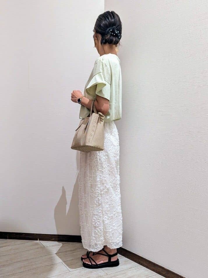 グリーン系のTシャツ/カットソー、ホワイト系のスカート、ブラック系のサンダルを着用したレディースの夏コーディネートの3枚目の写真