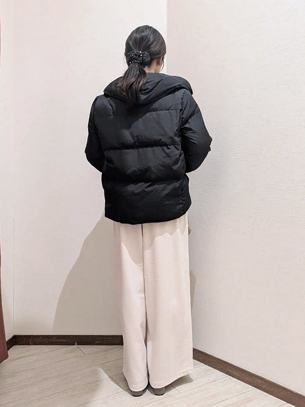 ブラック系のダウンジャケット/コート、レッド系のニット/セーター、ホワイト系のその他パンツを着用したレディースの冬コーディネートの4枚目の写真