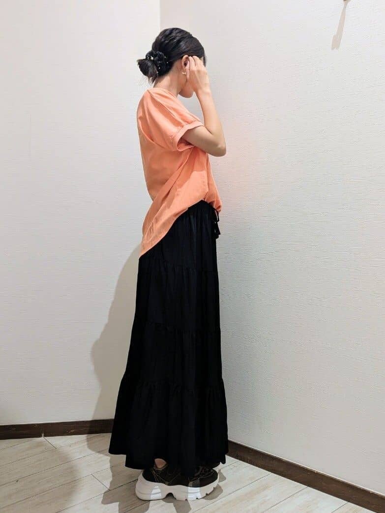 オレンジ系のシャツ/ブラウス、ブラック系のスカート、ブラウン系のスニーカーを着用したレディースの夏コーディネートの3枚目の写真