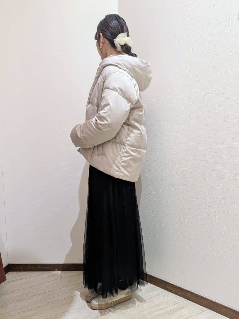 ベージュ系のダウンジャケット/コート、グリーン系のニット/セーター、ブラック系のスカートを着用したレディースの冬コーディネートの3枚目の写真