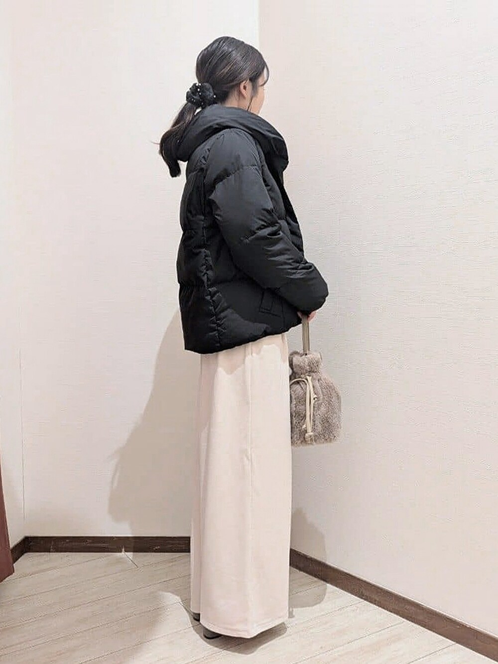 ブラック系のダウンジャケット/コート、レッド系のニット/セーター、ホワイト系のその他パンツを着用したレディースの冬コーディネートの3枚目の写真