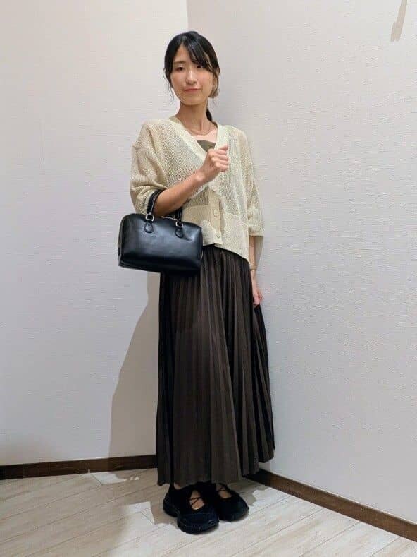 ベージュ系のカーディガン/ボレロ、ブラウン系のスカート、ブラック系のスニーカーを着用したレディースの秋コーディネートの2枚目の写真