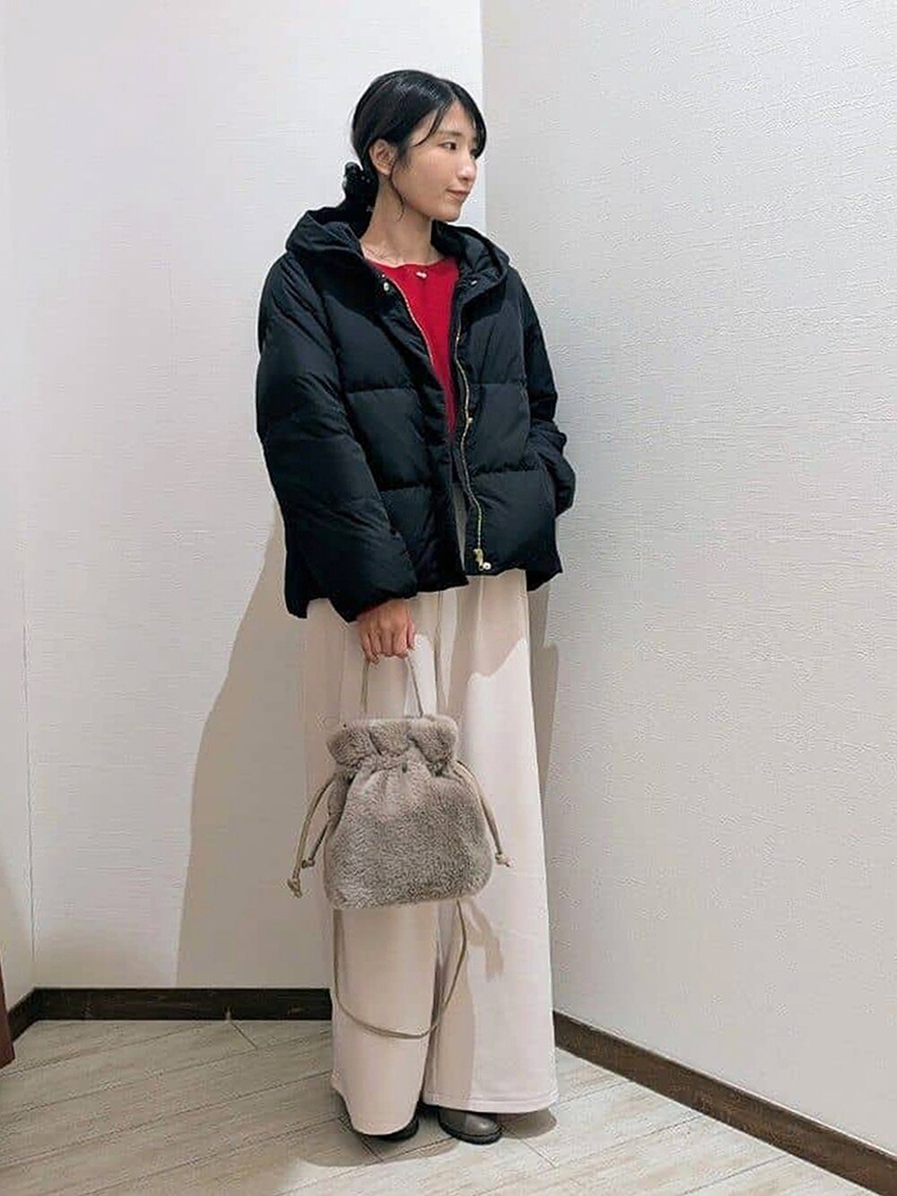 ブラック系のダウンジャケット/コート、レッド系のニット/セーター、ホワイト系のその他パンツを着用したレディースの冬コーディネートの2枚目の写真