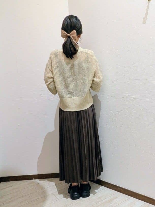 ベージュ系のカーディガン/ボレロ、ブラウン系のスカート、ブラック系のスニーカーを着用したレディースの秋コーディネートの4枚目の写真