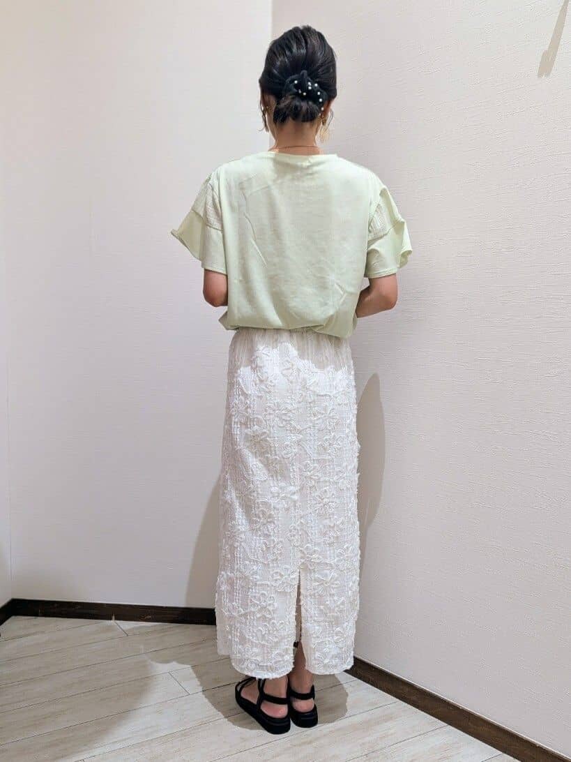 グリーン系のTシャツ/カットソー、ホワイト系のスカート、ブラック系のサンダルを着用したレディースの夏コーディネートの4枚目の写真