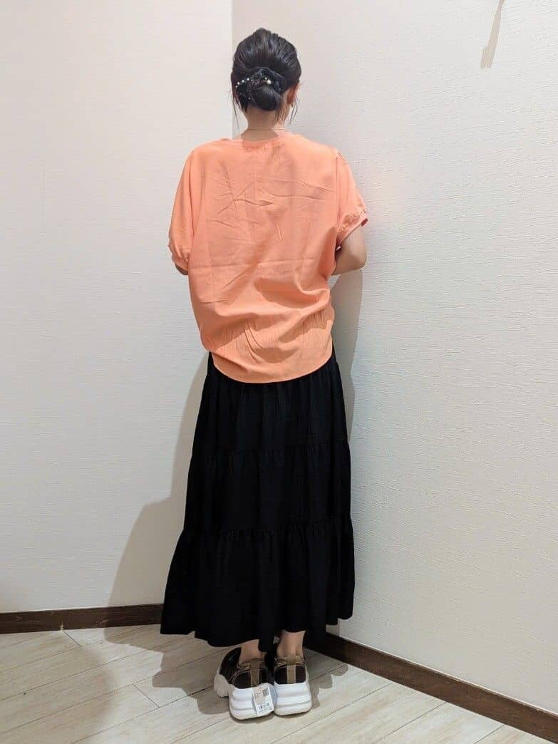 オレンジ系のシャツ/ブラウス、ブラック系のスカート、ブラウン系のスニーカーを着用したレディースの夏コーディネートの4枚目の写真