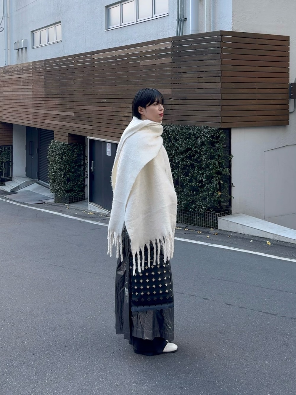 ブラック系のトートバッグ、シルバー系のスカート、ホワイト系のブーツを着用したメンズの冬コーディネートの4枚目の写真