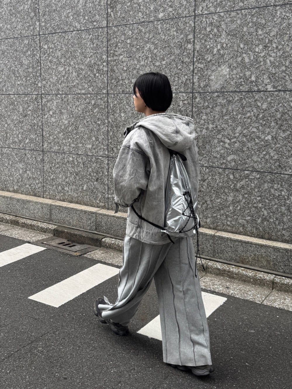 ホワイト系のマウンテンパーカー、グレー系のスウェットパンツ、シルバー系のバックパック/リュックを着用したメンズの春コーディネートの2枚目の写真