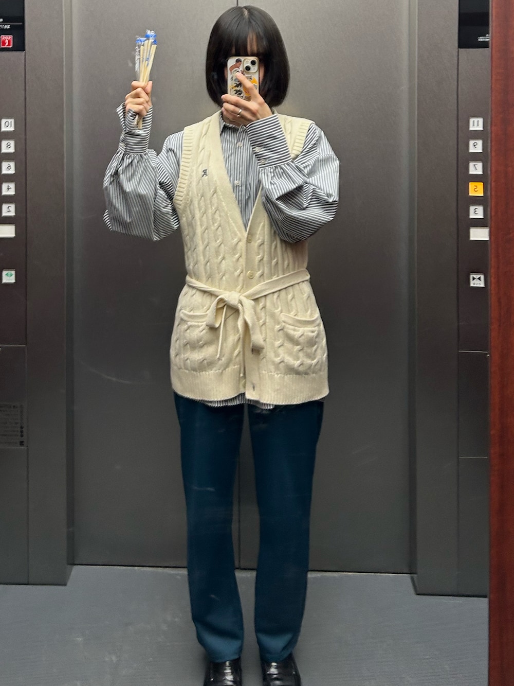 ベージュ系のベスト、ブラック系のシャツ/ブラウス、ブラック系のローファーを着用したレディースの夏コーディネートの2枚目の写真