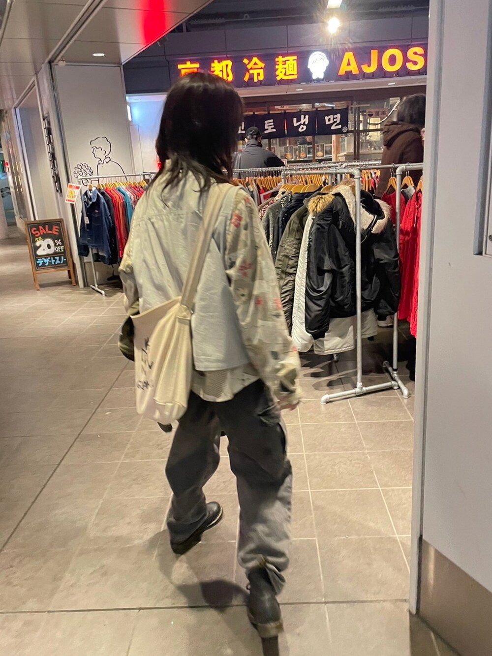 ブラック系のブーツ、ベージュ系のショルダーバッグを着用したレディースの夏コーディネートの2枚目の写真