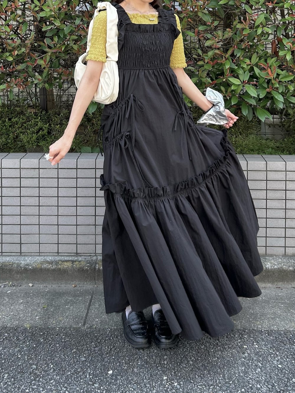 イエロー系のTシャツ/カットソー、ブラック系のワンピース、ブラック系のローファーを着用したレディースの秋コーディネートの2枚目の写真