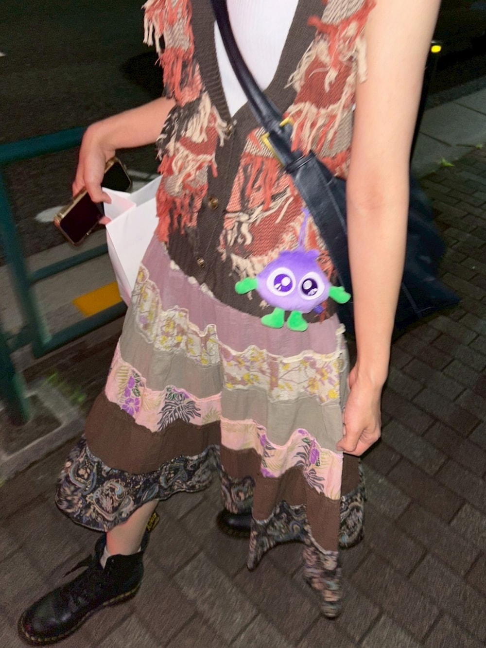 ブラック系のブーツ、ブラウン系のベスト、ブラウン系のスカートを着用したレディースの夏コーディネートの2枚目の写真